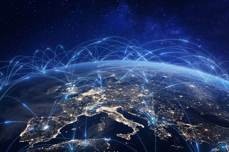 Image of Europe at night on a globe, with arcing blue lines linking various locations