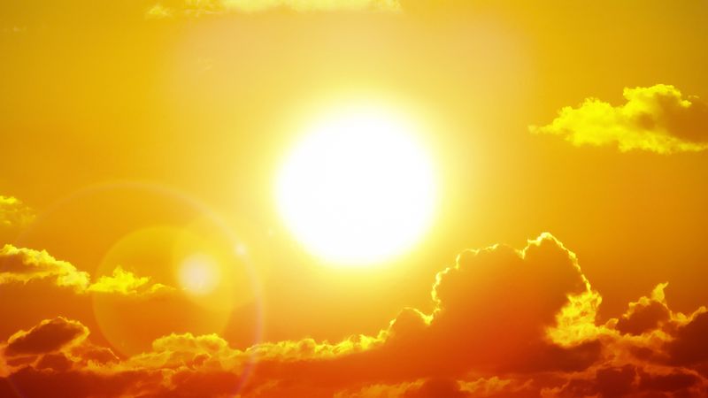 bright sun against an orange sky with clouds